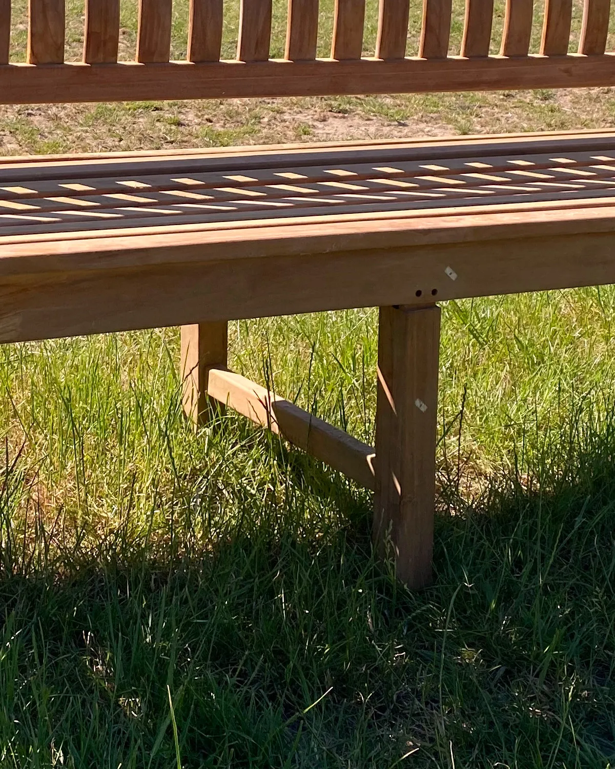 De middenpoot onder een teakbank van 210 cm