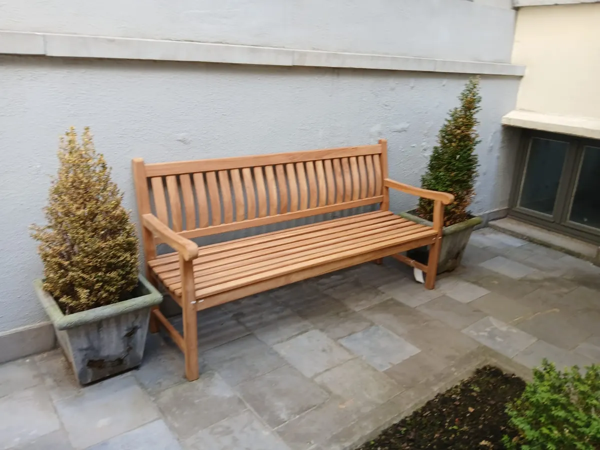 Teakbank in een binnenkoer tussen twee planten