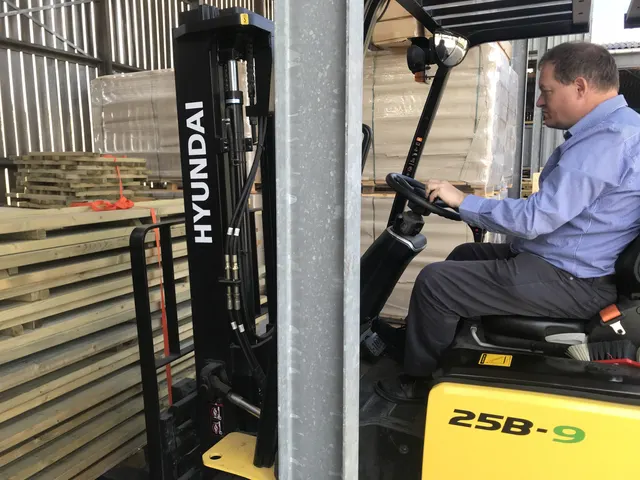 Mark op de heftruck in het magazijn, 2018